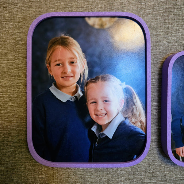 Two children in school uniforms with a purple border on a textured surface