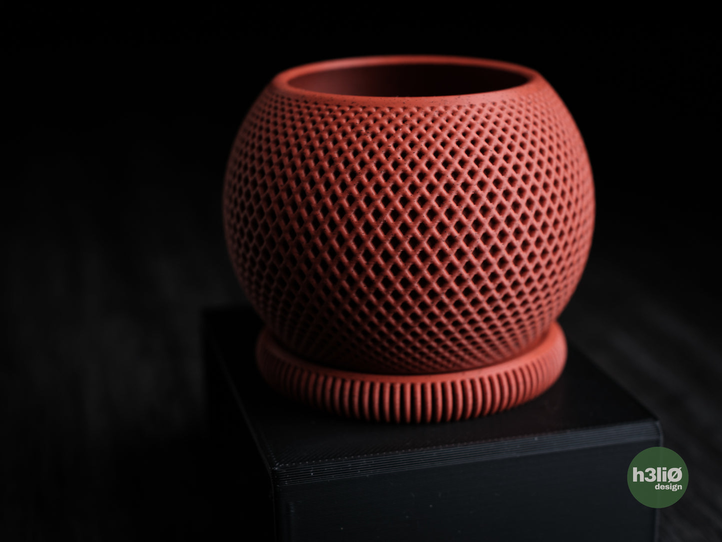 Red ceramic pot with textured surface on a dark background