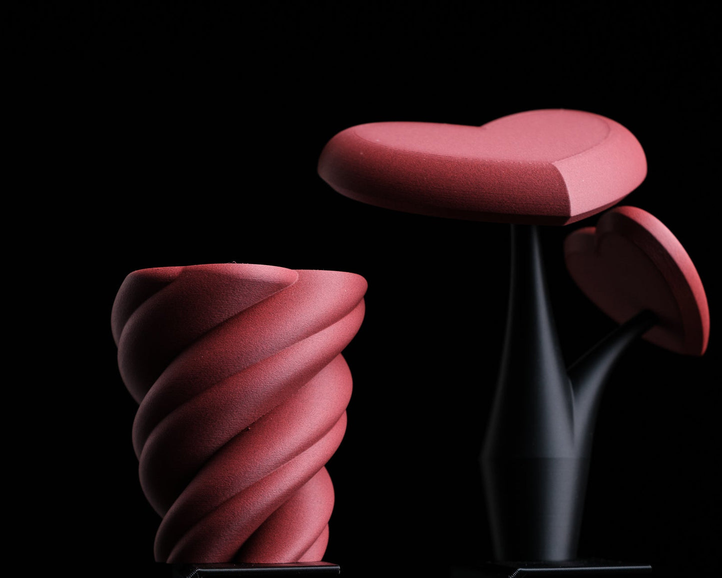 Pink, wavy, abstract sculpture on a black background with 'h310 design' logo.