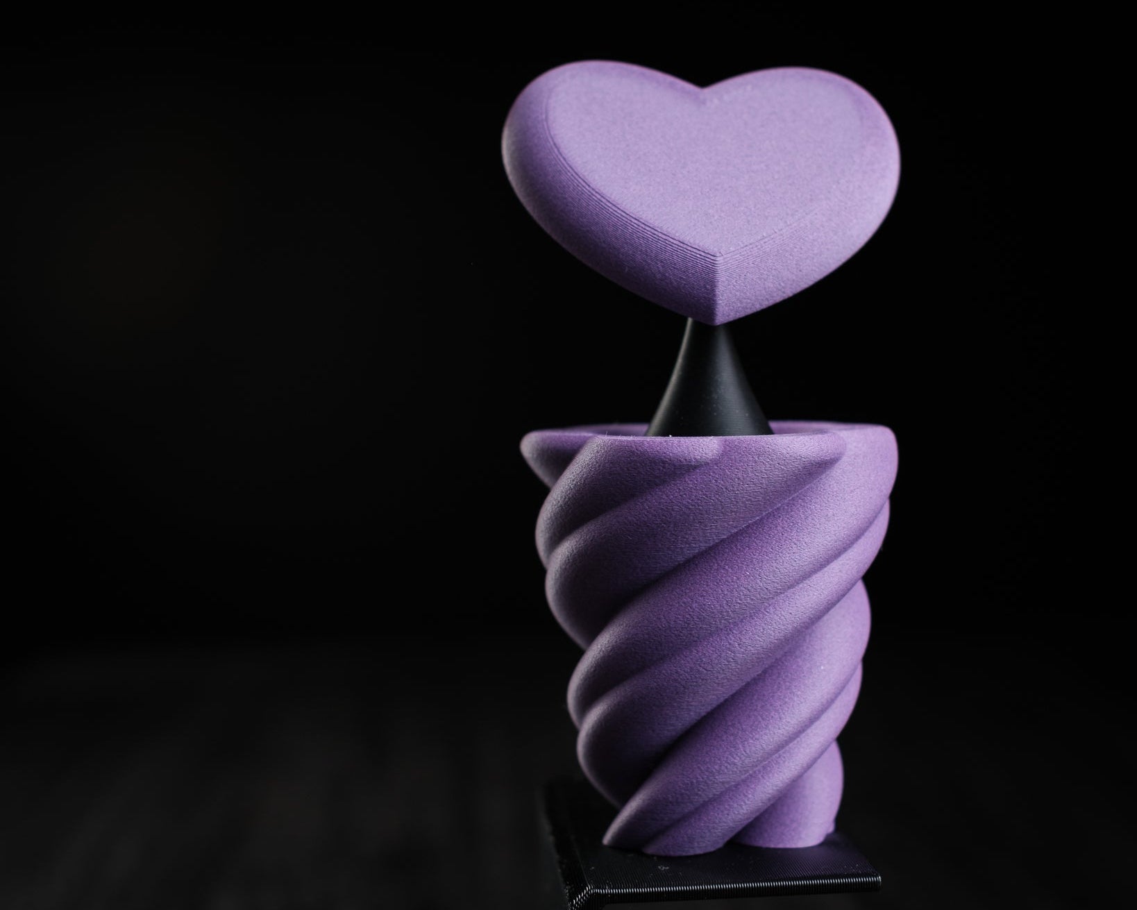 Purple heart-shaped object on a black background