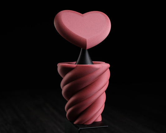 Pink heart-shaped object on a black background with 'h310 design' logo.