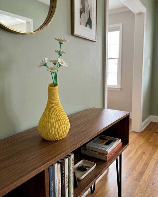 Yellow vase with flowers on a wooden shelf in a room with green walls and a door.